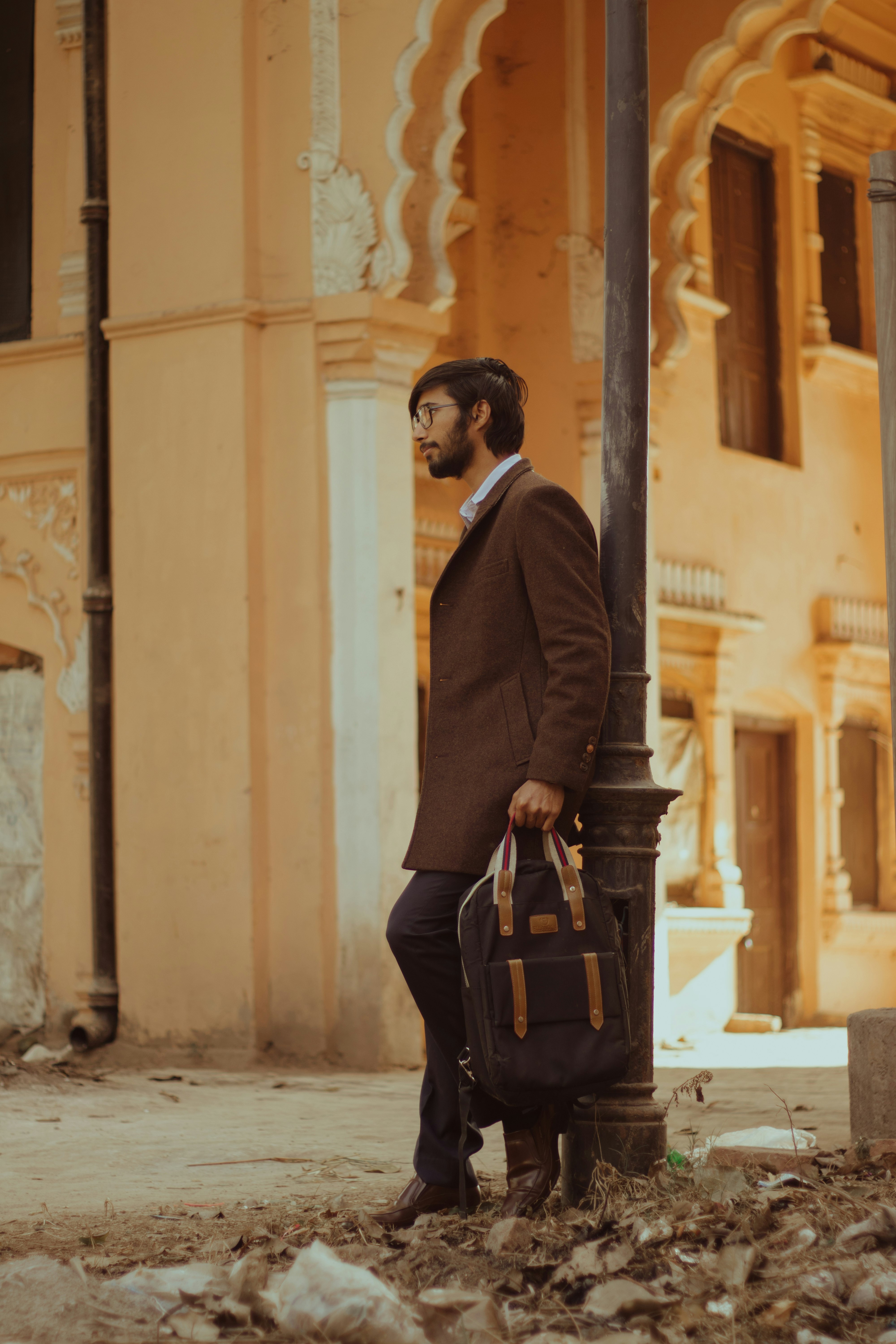 man in black blazer and black pants carrying black leather handbag